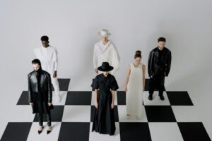 Fashion models dressed in black and white on a chessboard pattern, showcasing a conceptual style.